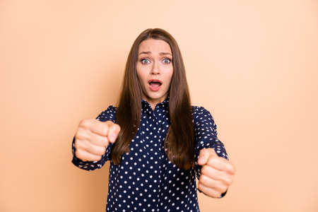 Photo of shocked shiny young girl dressed dotted blouse driving car open mouth isolated beige color backgroundの写真素材