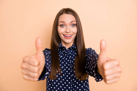 Photo of young woman happy positive smile show thumb-up like cool advert advice isolated over beige color backgroundの写真素材