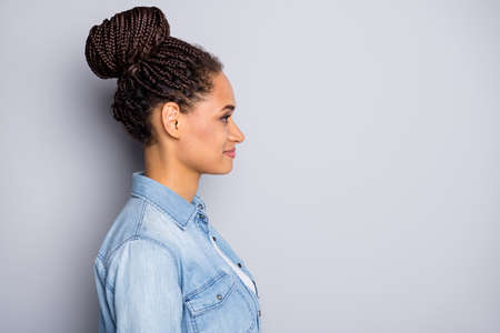 Side profile photo portrait girl with braids looking copyspace smiling isolated on grey color backgroundの写真素材