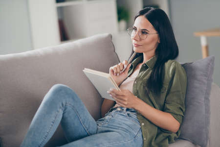 Portrait of attractive creative minded girl journalist sitting on divan creating new article at home...