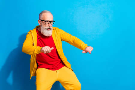 Photo of mature funky funny cool hipster man in glasses dancing look copyspace isolated on blue...