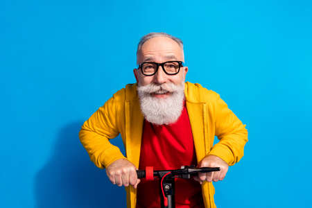 Photo of cheerful carefree person driving fast moped toothy smile look camera isolated on blue color...