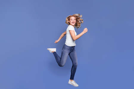 Full length body size view of charming glad cheerful wavy-haired girl jumping running isolated over...