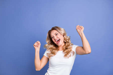 Portrait of attractive lucky cheerful wavy-haired girl celebrating having fun isolated over blue color backgroundの写真素材