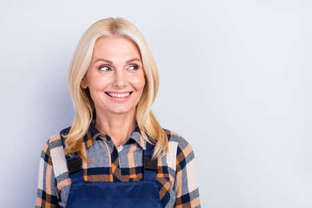 Photo of pretty adorable age crafts lady dressed blue uniform smiling looking empty space isolated grey color backgroundの写真素材
