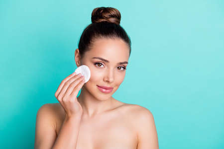 Portrait of nice brown hairdo lady apply make up without clothes isolated on teal color backgroundの写真素材