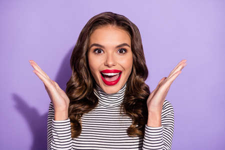 Close-up portrait of attractive cheerful lucky wavy-haired girl applauding having fun isolated over bright violet purple color backgroundの写真素材