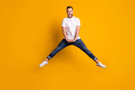 Full length body size photo of cheerful happy jumping man childish playful laughing isolated vivid...