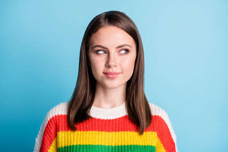 Photo of shiny tricky young lady wear striped outfit looking empty space isolated blue color backgroundの写真素材