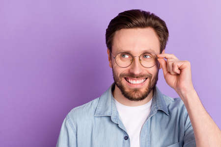 Photo of dreamy young happy man look empty space wear glasses imagine isolated on purple color backgroundの写真素材