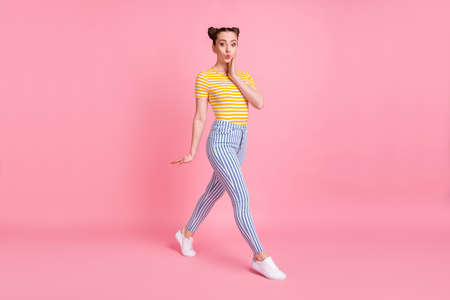 Full size photo of impressed brunette lady go hand face wear yellow t-shirt pants sneakers isolated...