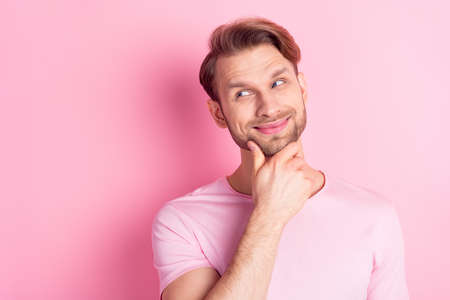 Portrait of positive person hand on chin look empty space smile thinking isolated on pink color backgroundの写真素材
