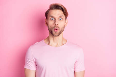 Photo of sweet shocked young guy wear casual clothes big eyes pouted lips isolated pink color backgroundの写真素材