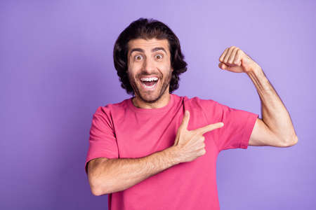 Photo of impressed nice brunet guy point arm wear pink t-shirt isolated on pastel violet color...
