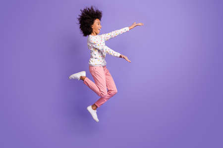 Full size profile side photo of afro american little girl jump open hands copyspace isolated on...
