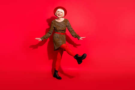 Full size photo of cheerful aged woman happy positive smile have fun dance party isolated over red color backgroundの写真素材