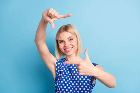 Photo of young attractive girl happy positive smile show fingers border frame sign photographing...
