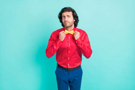 Photo of young handsome good looking thoughtful man adjust bow tie prepare to party isolated on...