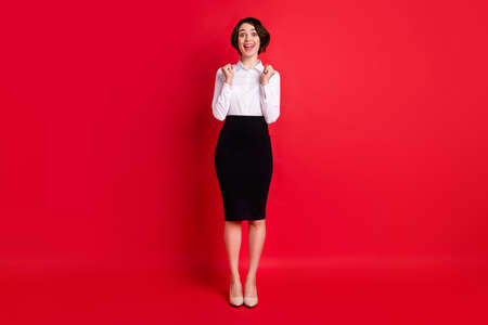 Full length body size photo business woman gesturing like winner overjoyed isolated bright red color backgroundの写真素材