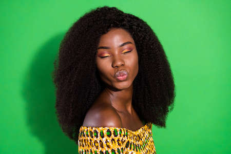 Photo of young beautiful stunning gorgeous afro woman pout lips kiss dreaming isolated on green color backgroundの写真素材