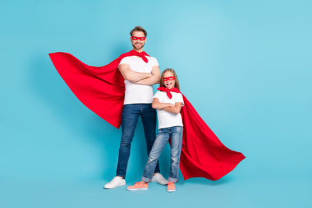 Full length portrait of two confident persons folded arms wear red hero costume isolated on blue color backgroundの写真素材