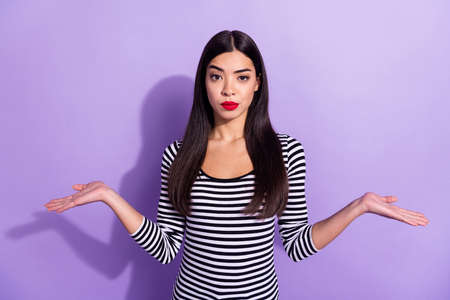 Photo of young unhappy displeased woman shrug shoulders clueless dissatisfied isolated on violet...