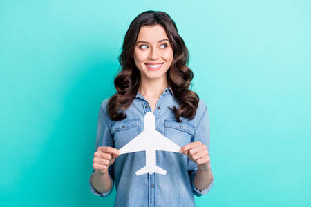 Photo of young girl happy positive smile hold paper plane dream trip look empty space isolated over...