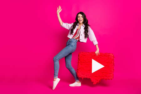 Full length photo of charming funny young woman wear jeans jacket waving arm holding pinata isolated bright pink color backgroundの写真素材