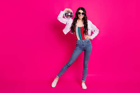 Full size photo of optimistic brunette lady hold disco ball wear spectacles top jeans jacket sneakers isolated on pink backgroundの写真素材