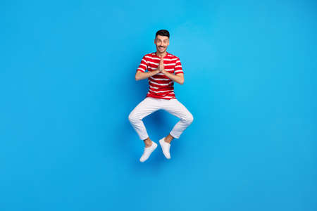 Full body photo of attractive cheerful guy jump up air clap hands isolated on pastel blue color backgroundの写真素材
