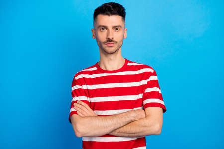 Photo of serious young confident man folded hands wear casual outfit isolated on pastel blue color backgroundの写真素材