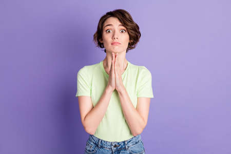 Portrait of lovely thankful amazed brown-haired girl asking forgive me isolated over violet color...