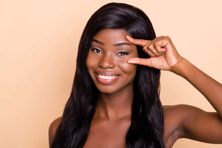 Photo of shiny pretty dark skin  woman fingers check eyebrow correction isolated beige color...