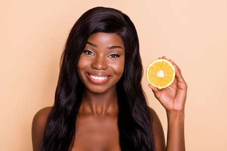 Photo of cheerful positive model lady hold tasty orange slice toothy beaming smile isolated beige backgroundの写真素材