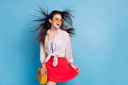 Portrait of attractive fashionable cheerful dreamy girl throwing hair good mood isolated over bright blue color backgroundの写真素材