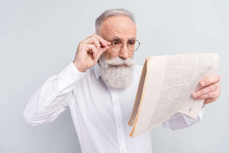 Photo of aged man hand touch glasses read newspaper magazine news isolated over grey color backgroundの写真素材