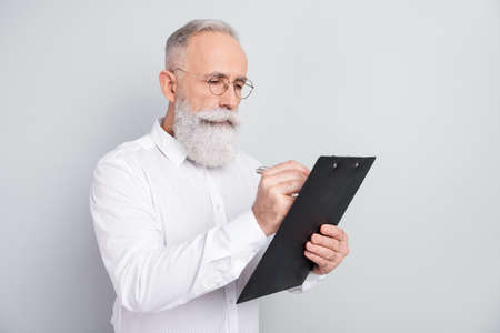 Photo of minded focused serious old man look write clipboard plan businessman isolated on grey color...