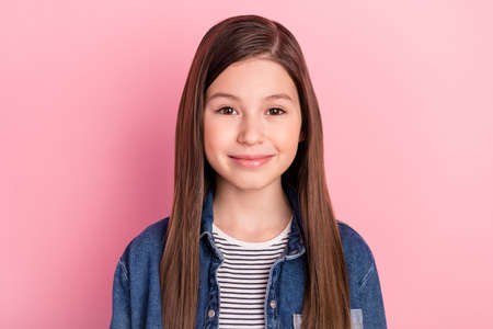 Photo portrait of happy smiling schoolgirl wearing jeans jacket isolated on pastel pink color backgroundの写真素材