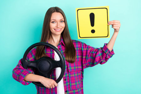 Photo of funny long hairdo young lady drive car hold warner wear checkered shirt isolated on vivid teal color backgroundの写真素材