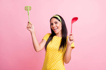 Photo of happy pretty housewife hold spoon masher good mood isolated on pastel shine pink color backgroundの写真素材
