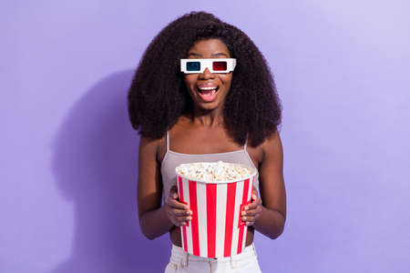Photo of excited black woman happy positive smile watch movie 3d glasses eat popcorn isolated over...