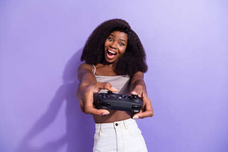 Photo of young cheerful african woman happy positive smile play video game joystick isolated over...