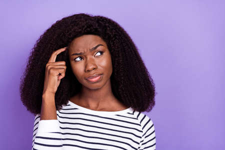 Photo of young african girl finger touch head think memory remember look empty space isolated over...