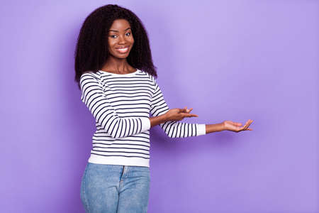 Photo of sweet young lady point hold empty space wear striped pullover isolated on violet color backgroundの写真素材