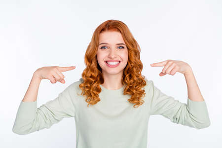 Photo portrait of red haired woman pointing at white teeth smile isolated white color backgroundの写真素材
