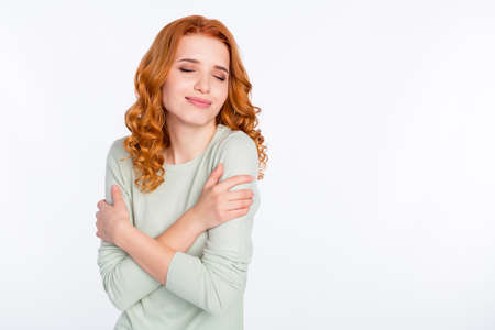 Photo portrait of red haired girl dreamy positive cuddling herself closed eyes isolated white color background with copyspaceの写真素材