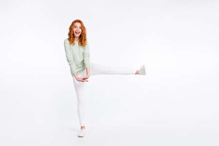 Full length body size photo young woman red hair cheerful happy keeping leg up funny laughing isolated white color backgroundの写真素材