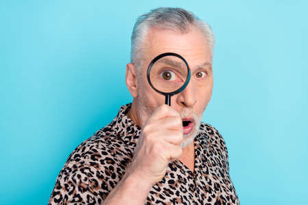 Photo of shocked amazed old man hold hand magnifier look zoom eye isolated on pastel blue color...