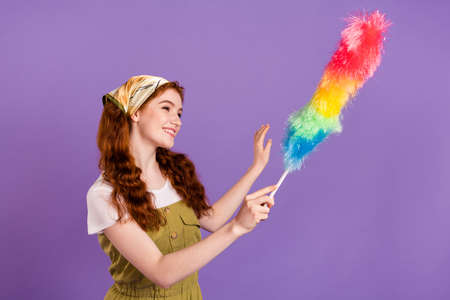Portrait of attractive cheerful girl wiping dust domestic everyday duty isolated over violet purple color backgroundの写真素材