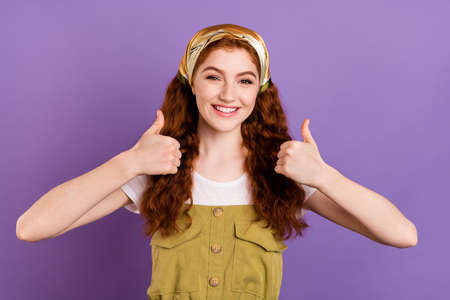 Photo of cheerful positive young woman hold hands show thumbs up smile isolated on purple color backgroundの写真素材
